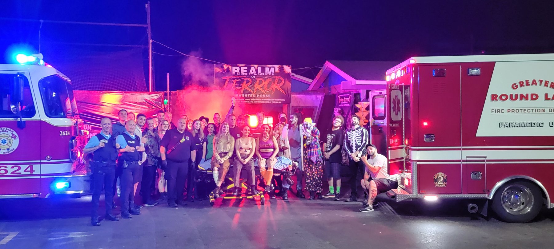 Cast and crew posed with fire and rescue vehicles outside Realm of Terror.