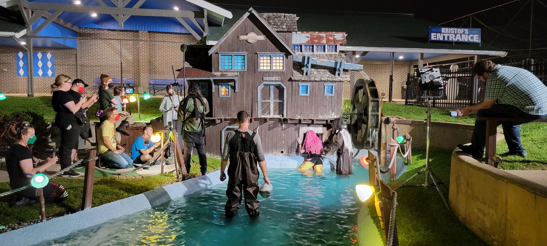 A wider look at the Haunt Season crew working around the water-wheel scene.