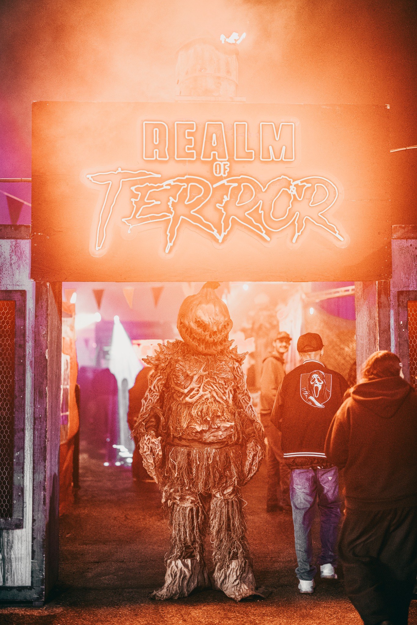 Pumpkin creature beneath the Realm of Terror entrance sign during the 2025 season