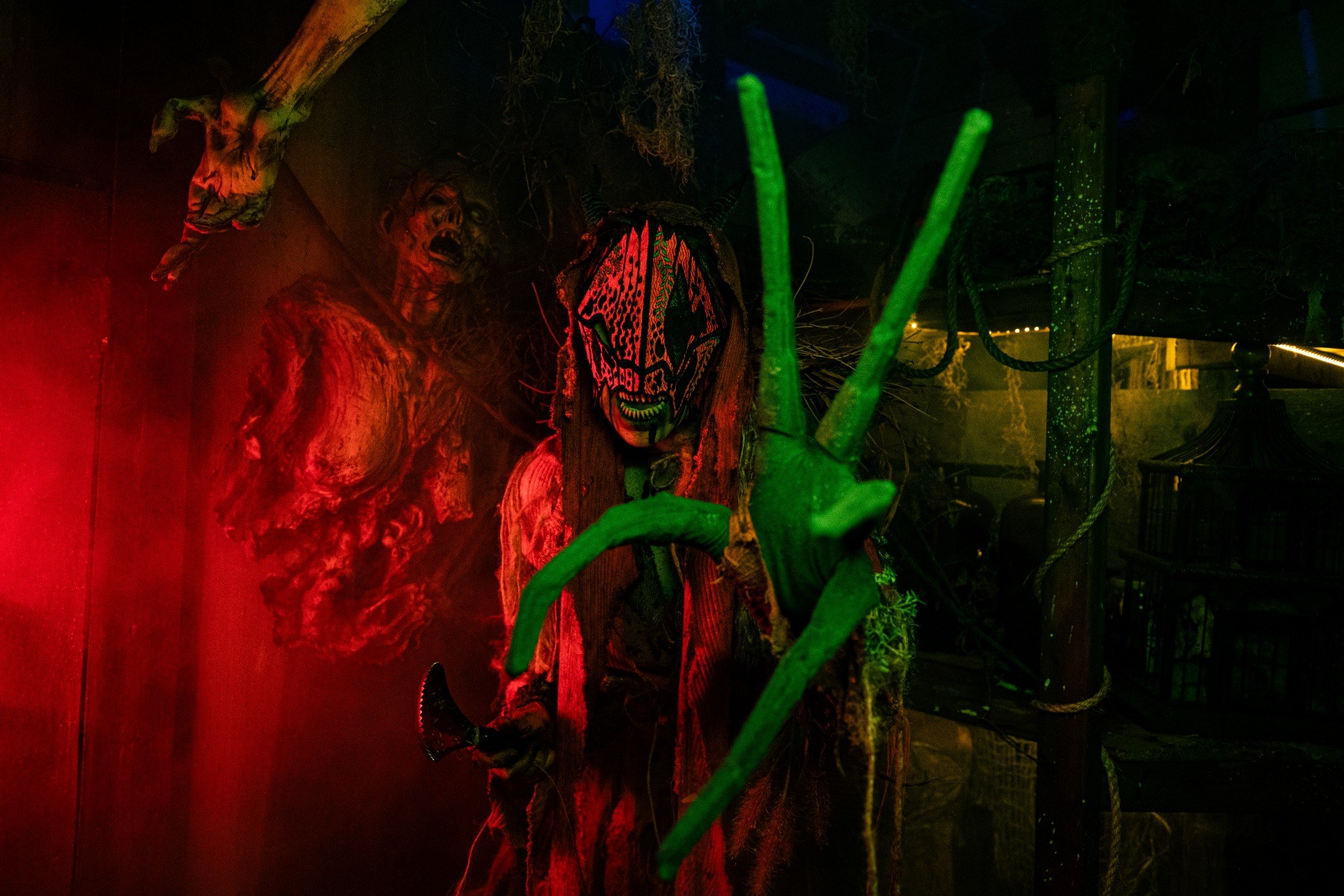 Live Realm of Terror creature performing in a red and green haunted environment